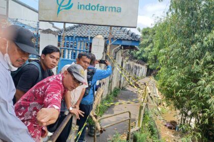 Anggota Lembaga Musyawarah Kelurahan (LMK) RW 03 Kebon Manggis, Rudi Hartono (batik merah memakai topi) bersama warga dan ketua RT 08 RW 03, Kelurahan Kebon Manggis, Kecamatan Matraman, Jakarta Timur, pada Selasa (8/4/2025) siang, menunjukkan akses jalan rusak dan turap Sungai Ciliwung yang longsor. Foto: Joesvicar Iqbal/ipol.id
