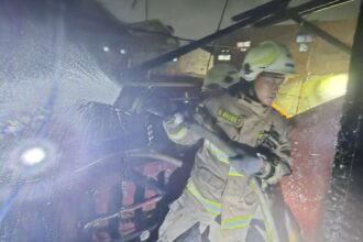 Petugas berjibaku memadamkan api yang membakar rumah di Jalan Tanah Koja 2, RT 007 RW 02, no 15, Kelurahan Jatinegara Kaum, Kecamatan Pulo Gadung, Jakarta Timur, Senin (5/5/2025) malam. Foto: Ist
