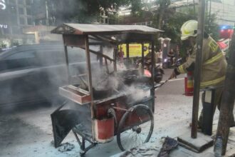 Petugas Damkar memadamkan gerobak pedagang yang terbakar di Jalan Utan Kayu, Kecamatan Matraman, Jakarta Timur, Senin (12/5/2025) sore. Foto: Ist