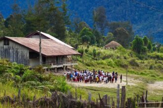 Ilustrasi. Murid-murid berbaris sebelum memasuki ruang kelas di sebuah sekolah dasar yang bangunannya terbuat dari kayu di Ilaga, Puncak, Papua. Foto: Wangsa Nayottama/Shutterstock