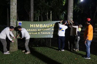Suasana aparat Satpol PP Jakarta Selatan saat memasang spanduk larangan berbuat asusila di area Taman Langsat, Kebayoran Baru. Wakil Kepala Satpol PP DKI Jakarta, Rizki Adhari meninjau pemasangan spanduk larangan, Jumat (13/6/2025) malam. Foto: Ist