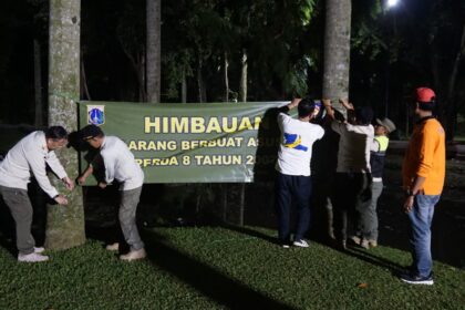 Suasana aparat Satpol PP Jakarta Selatan saat memasang spanduk larangan berbuat asusila di area Taman Langsat, Kebayoran Baru. Wakil Kepala Satpol PP DKI Jakarta, Rizki Adhari meninjau pemasangan spanduk larangan, Jumat (13/6/2025) malam. Foto: Ist