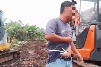 Seorang pria menunjukan pistol saat berada di lahan sengketa yang terjadi di Rumah Pemotongan Hewan (RPH) Rangkapan Jaya Lama, Kecamatan Cinere, Kota Depok, Jawa Barat. Foto: Tangkap layar IG @medsoszone