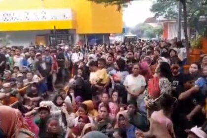 Suasana ribuan warga dan pedagang rela antri hujan-hujanan untuk mendapatkan daging kurban dari panita Idul Adha 1446 Hijriah di area Pasar Induk Kramat Jati, Jakarta Timur, Sabtu (7/6/2025) sore. Foto: Ist