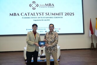 Wakil Direktur Utama Telkom Muhammad Awaluddin saat menerima cinderamata dari perwakilan mahasiswa UGM pada acara MBA Catalyst Summit 2025 di Universitas Gadjah Mada (UGM), pada Sabtu (5/7/2025). Foto: Telkom Indonesia
