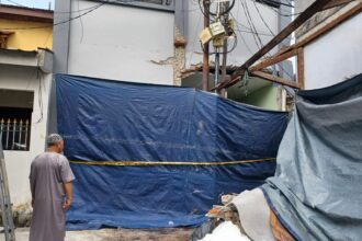 Kondisi rumah dan empat indekos porak poranda di perumahan Jalan Wijaya Kusuma, Gang 7, RT 04/07, Kelurahan Malaka Sari, Kecamatan Duren Sawit, Jakarta Timur, Senin (21/7/2025), ditutupi terpal dan dipasangi garis police line. Foto: Joesvicar Iqbal/ipol.id