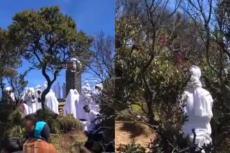 Puluhan orang berpakaian putih-putih mengelilingi tugu Trianggulasi di puncak Gunung Lawu. Foto: Tangkap layar TikTok @faiiiiiqq._