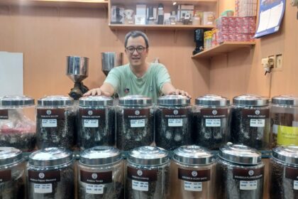 Pemilik Toko Kopi Cap Bemo, Edward Nurjadi menunjukkan beragam biji kopi pilihan nusantara di Pasar Rawamangun, Pulo Gadung, Jakarta Timur, Senin (25/8/2025). Foto: Joesvicar Iqbal/ipol.id