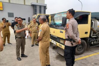 Kasi Ops Penindakan Pol PP Jakarta Timur, Charles Siahaan bersama Kasi Penegakan Hukum (Gakkum) Dinas Lingkungan Hidup DKI Jakarta, Hugo Efraim dan jajaran, menunjukkan barang bukti tiga truk pembuang limbah tinja di kawasan Jalan DI Panjaitan, Kecamatan Jatinegara, Senin (11/8/2025) pagi. Foto: Joesvicar Iqbal/ipol.id