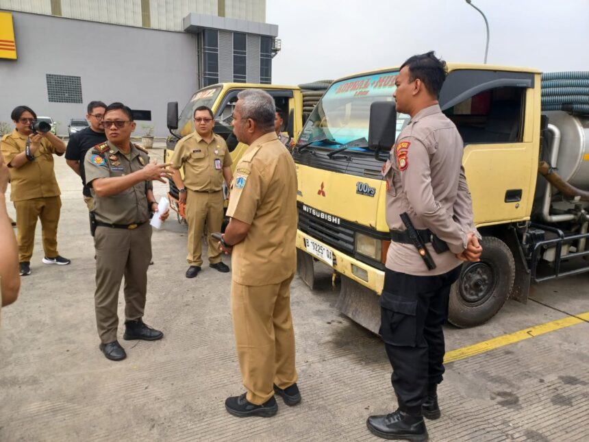 Kasi Ops Penindakan Pol PP Jakarta Timur, Charles Siahaan bersama Kasi Penegakan Hukum (Gakkum) Dinas Lingkungan Hidup DKI Jakarta, Hugo Efraim dan jajaran, menunjukkan barang bukti tiga truk pembuang limbah tinja di kawasan Jalan DI Panjaitan, Kecamatan Jatinegara, Senin (11/8/2025) pagi. Foto: Joesvicar Iqbal/ipol.id
