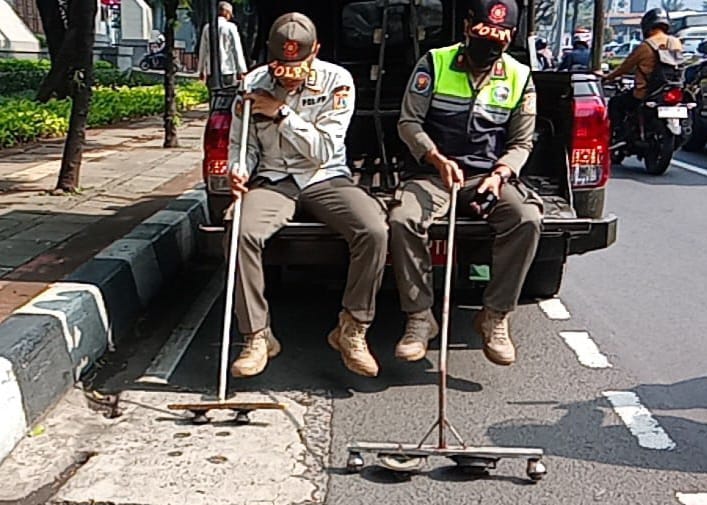 Dua petugas Satuan Polisi Pamong Praja Kecamatan Kebayoran Baru, Jakarta Selatan, saat melakukan razia ranjau paku di kawasan Senayan, Kebayoran Baru, Rabu (13/8/2025). Foto: Joesvicar Iqbal/ipol.id