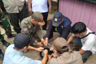 Sejumlah petugas gabungan, Satuan Polisi Pamong Praja (Satpol PP) Kelurahan Ciganjur, Kecamatan Jagakarsa, Jakarta Selatan, memusnahkan langsung temuan obat-obatan terlarang dijual bebas oleh pedagang kios pulsa di Jalan Brigif Raya, RT 012 RW 06, Ciganjur, Jagakarsa, Rabu (20/8/2025) siang. Foto: Joesvicar Iqbal/ipol.id