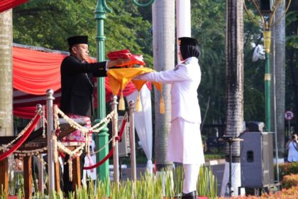 Wali Kota Administrasi Jakarta Timur, Munjirin, Pembina Upacara dalam Peringatan Hari Ulang Tahun (HUT) Kemerdekaan ke-80 Republik Indonesia (RI), menerima bendera merah putih dari Paskibraka di halaman Kantor Walikota Jakarta Timur, Minggu (17/8/2025). Foto: Ist