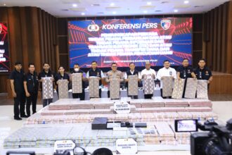 Dirtipideksus Bareskrim Polri, Brigjen Pol Helfi Assegaf dan jajaran menunjukkan barang bukti uang ratusan miliar rupiah, 22 unit ponsel, 1 hard disk eksternal, 2 DVR CCTV, 1 mini PC dan 1 laptop Asus ROG, dalam konferensi pers pengungkapan jaringan sindikat pembobolan rekening bank dormant dengan total kerugian mencapai Rp204 miliar di Bareskrim Polri, Kamis (25/9/2025). Foto: Ist