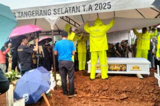 Peti jenazah almarhum diturunkan ke liang lahat dengan khidmat.