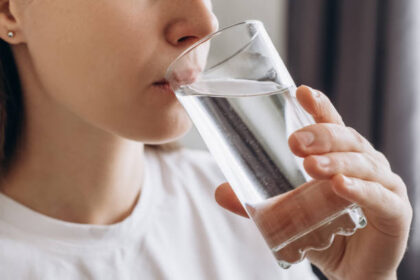 Wanita menikmati minum air mineal yang menjadi kebiasaan sehari-hari gaya hidup sehat. Foto: Istcok @Yurii Yarema