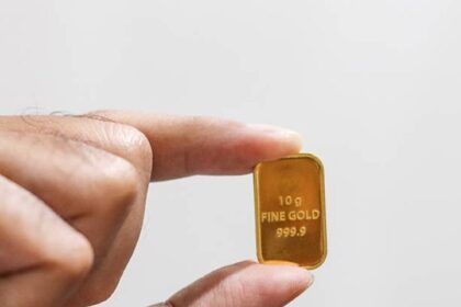 Ilustrasi tangan memegang emas antam batangan bersertifikat 10 gram. Foto: Istcok @Muhammad Faris