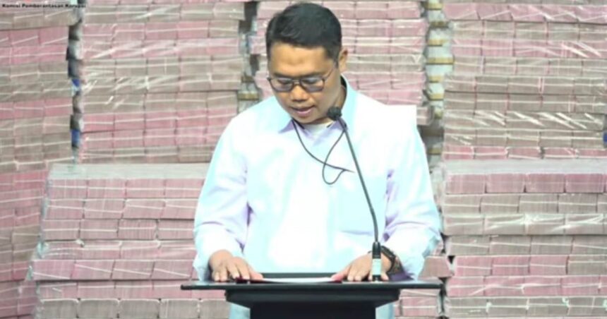 Plt Deputi Penindakan dan Eksekusi KPK Asep Guntur Rahayu saat memamerkan uang hasil rampasan negara atas perkara investasi fiktif PT Taspen bernilai ratusan miliar. Foto: Live streaming YouTube KPK