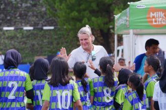Head Coach MilkLife Soccer Challenge, Timo Scheunemann menyapa siswi-siswi yang berlaga di MilkLife Soccer Challenge Jakarta Seri 1 2025 - 2. Foto/Megapro