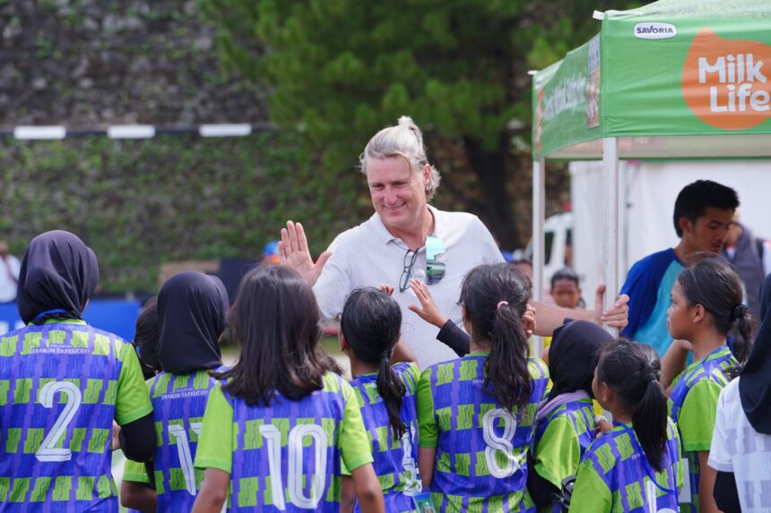 Head Coach MilkLife Soccer Challenge, Timo Scheunemann menyapa siswi-siswi yang berlaga di MilkLife Soccer Challenge Jakarta Seri 1 2025 - 2. Foto/Megapro