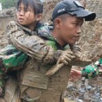 Salah seorang prajurit TNI AD tengah mengevakuasi seorang anak yang terdampak bencana di Kota Padang Panjang. Foto: Dispenad