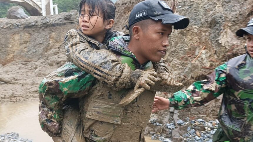 Salah seorang prajurit TNI AD tengah mengevakuasi seorang anak yang terdampak bencana di Kota Padang Panjang. Foto: Dispenad