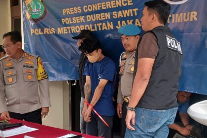 Penampakan pelaku berinisial RS alias EJA, 25, saat dikawal oleh penyidik ketika dihadirkan dalam konferensi pers pengungkapan kasus pencurian di Polsek Duren Sawit, Jakarta Timur, Jumat (28/11/2025) sore. Foto: Joesvicar Iqbal/ipol.id