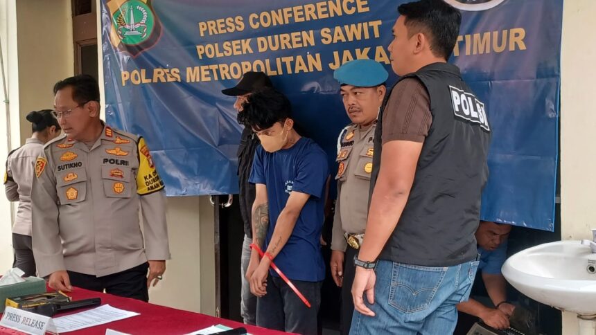 Penampakan pelaku berinisial RS alias EJA, 25, saat dikawal oleh penyidik ketika dihadirkan dalam konferensi pers pengungkapan kasus pencurian di Polsek Duren Sawit, Jakarta Timur, Jumat (28/11/2025) sore. Foto: Joesvicar Iqbal/ipol.id