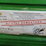 Perumda Pasar Jaya melalui pengelola Pasar Pramuka menempelkan stiker penutupan sementara kios pedagang yang tidak membayar sewa, Kamis (13/11/2025). Foto: Joesvicar Iqbal/ipol.id