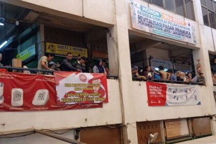 Suasana para pedagang Pasar Pramuka, Jakarta Timur memasang spanduk bertuliskan "Kami Mendukung Revitalisasi Pasar Pramuka Tapi Dengan Harga Yang Pantas dan Wajar", Kamis (13/11/2025). Foto: Joesvicar Iqbal/ipol.id