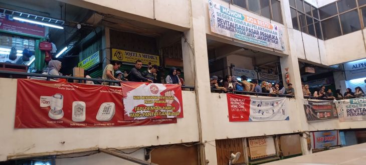 Suasana para pedagang Pasar Pramuka, Jakarta Timur memasang spanduk bertuliskan "Kami Mendukung Revitalisasi Pasar Pramuka Tapi Dengan Harga Yang Pantas dan Wajar", Kamis (13/11/2025). Foto: Joesvicar Iqbal/ipol.id