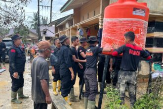 Sejumlah aparat Brimob Polri membantu memasang unit tandon air bersih sebagai bagian dari upaya penanganan bencana alam di wilayah Sumatera, termasuk bagi warga terdampak banjir bandang di Kabupaten Aceh Tamiang, Provinsi Aceh, Jumat (19/12/2025). Foto: Ist