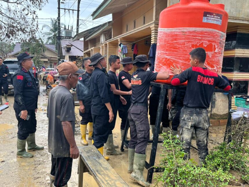 Sejumlah aparat Brimob Polri membantu memasang unit tandon air bersih sebagai bagian dari upaya penanganan bencana alam di wilayah Sumatera, termasuk bagi warga terdampak banjir bandang di Kabupaten Aceh Tamiang, Provinsi Aceh, Jumat (19/12/2025). Foto: Ist