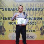 Anggota Satlantas Polres Sukabumi, Jawa Barat, Ipda Sandi Praja, menerima penghargaan dari Pemerintah Kabupaten (Pemkab) Sukabumi atas dedikasi dan prestasi serta kontribusi nyata dalam pembangunan dengan mendirikan sekolah gratis SMK Tunas Bhayangkara, Kamis (11/12/2025). Foto: Ist
