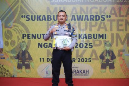 Anggota Satlantas Polres Sukabumi, Jawa Barat, Ipda Sandi Praja, menerima penghargaan dari Pemerintah Kabupaten (Pemkab) Sukabumi atas dedikasi dan prestasi serta kontribusi nyata dalam pembangunan dengan mendirikan sekolah gratis SMK Tunas Bhayangkara, Kamis (11/12/2025). Foto: Ist