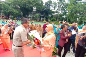 Wali Kota Jakarta Selatan, M Anwar, bersama Wakil Wali Kota Ali Murtadho memberikan bunga mawar ke istrinya dalam suasana penuh keceriaan dan kemesraan mewarnai peringatan Hari Ulang Tahun (HUT) ke-26 Dharma Wanita Persatuan (DWP) dirangkaikan memperingati Hari Ibu ke-97 di Halaman Kantor Walikota Administrasi Jakarta Selatan, Selasa (16/12/2025). Foto: Joesvicar Iqbal/ipol.id