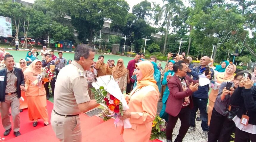 Wali Kota Jakarta Selatan, M Anwar, bersama Wakil Wali Kota Ali Murtadho memberikan bunga mawar ke istrinya dalam suasana penuh keceriaan dan kemesraan mewarnai peringatan Hari Ulang Tahun (HUT) ke-26 Dharma Wanita Persatuan (DWP) dirangkaikan memperingati Hari Ibu ke-97 di Halaman Kantor Walikota Administrasi Jakarta Selatan, Selasa (16/12/2025). Foto: Joesvicar Iqbal/ipol.id
