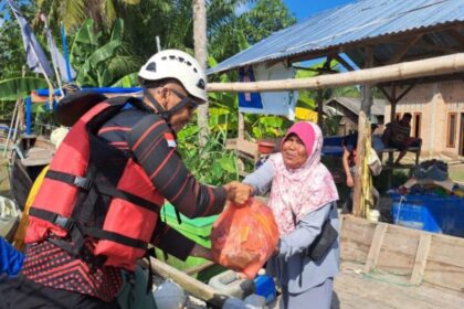 Relawan menyerahkan bantuan sembako kepada warga terdampak bencana di Desa Alur Kapal dan Kelurahan Pematang Cengal, Tanjung Pura, Langkat, Sumatra Utara, 5 Desember 2025. Foto: Ist