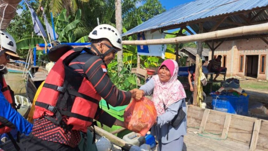 Relawan menyerahkan bantuan sembako kepada warga terdampak bencana di Desa Alur Kapal dan Kelurahan Pematang Cengal, Tanjung Pura, Langkat, Sumatra Utara, 5 Desember 2025. Foto: Ist