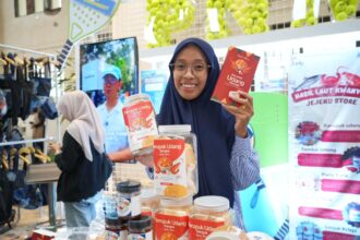 Ibu Imroatus Sofiyah, nasabah PNM Mekaar Cabang Surabaya yang telah bergabung PNM sejak 2020 dengan usaha Kerupuk Udang Sangrai yang ia kembangkan dari dapur rumahnya.