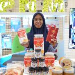 Ibu Imroatus Sofiyah, nasabah PNM Mekaar Cabang Surabaya yang telah bergabung PNM sejak 2020 dengan usaha Kerupuk Udang Sangrai yang ia kembangkan dari dapur rumahnya.