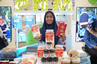 Ibu Imroatus Sofiyah, nasabah PNM Mekaar Cabang Surabaya yang telah bergabung PNM sejak 2020 dengan usaha Kerupuk Udang Sangrai yang ia kembangkan dari dapur rumahnya.