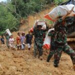 Prajurit tampak berjalan kaki sekitar lima kilometer untuk menyalurkan bantuan logistik ke Desa Naga Timbul, Desa Mompang, dan Desa Mardame setelah akses jalan menuju wilayah tersebut terputus total. Foto: Dispenad