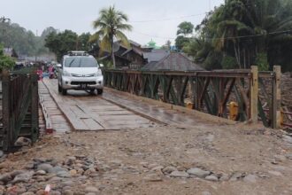 Kendaraan roda empat melintas di jembatan baily dari arah Provinsi Tapanuli Tengah menuju Tapanuli Selatan melalui Desa Garoga, Batang Toru, Minggu (14/12/2025). Foto: Ist