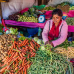 Ilustrasi seorang wanita menjual kebutuhan sayur mayur di pasar. Foto: Istock @hadynyah