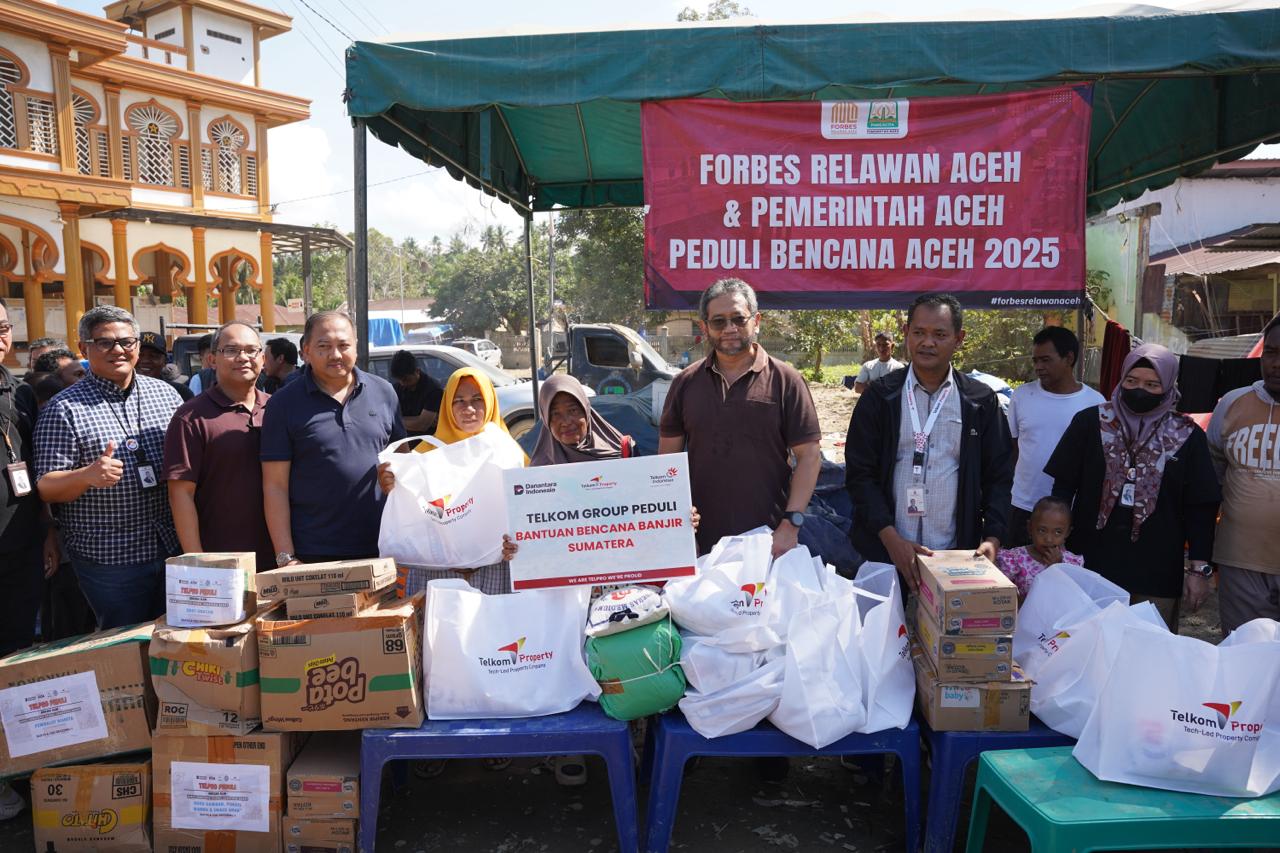 TelkomGroup Kejar Pemulihan Layanan Pascabencana di Aceh 2 Direktur Strategic Business Development & Portfolio Telkom Seno Soemadji (tengah) menyerahkan bantuan kemanusiaan kepada masyarakat terdampak bencana Kuala Simpang, Kabupaten Aceh Tamiang pada Selasa (23/12). Foto: Telkom Indonesia
