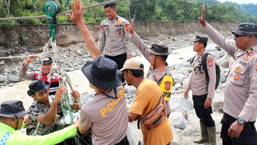 Polres Bener Meriah dan Brimob melaksanakan pemasangan tali sling sebagai jalur penyeberangan darurat bagi warga yang terisolir di tiga desa, yakni Desa Bergang, Desa Pantan Reduk, dan Desa Karang Ampar, Kabupaten Aceh Tengah. Foto: Dok Polres Bener Meriah