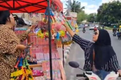 Suasana pedagang melayani seorang pembeli terompet di tenda lapak dagangan di kawasan surganya mainan anak-anak di Pasar Gembrong, Cipinang Besar Utara/Selatan, Jatinegara, Jakarta Timur, Minggu (28/12/2025) siang. Foto: Joesvicar Iqbal/ipol.id