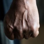 Ilustrasi - Seorang pria yang emosional mengepalkan jemari tangan dengan erat dan siap untuk meninju musuhnya. Foto: Freepik