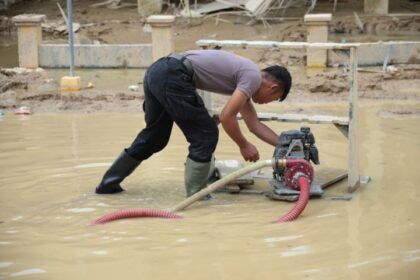 Personel Brimob Polda Aceh tengah menguras air dan lumpur tebal dengan mesin pompa di Kompi Senapan A Yonif 111 / Karma Bakti, Aceh Tamiang, yang terendam dampak bencana banjir, Jumat (26/12/2025). Foto: Ist